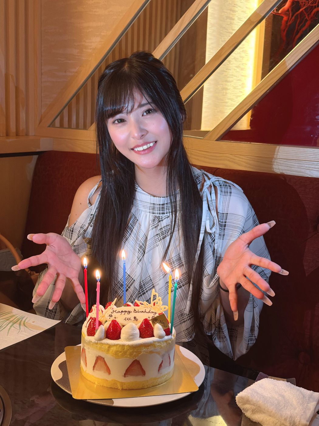 名前入りのバースデーケーキを前に笑顔のタレント