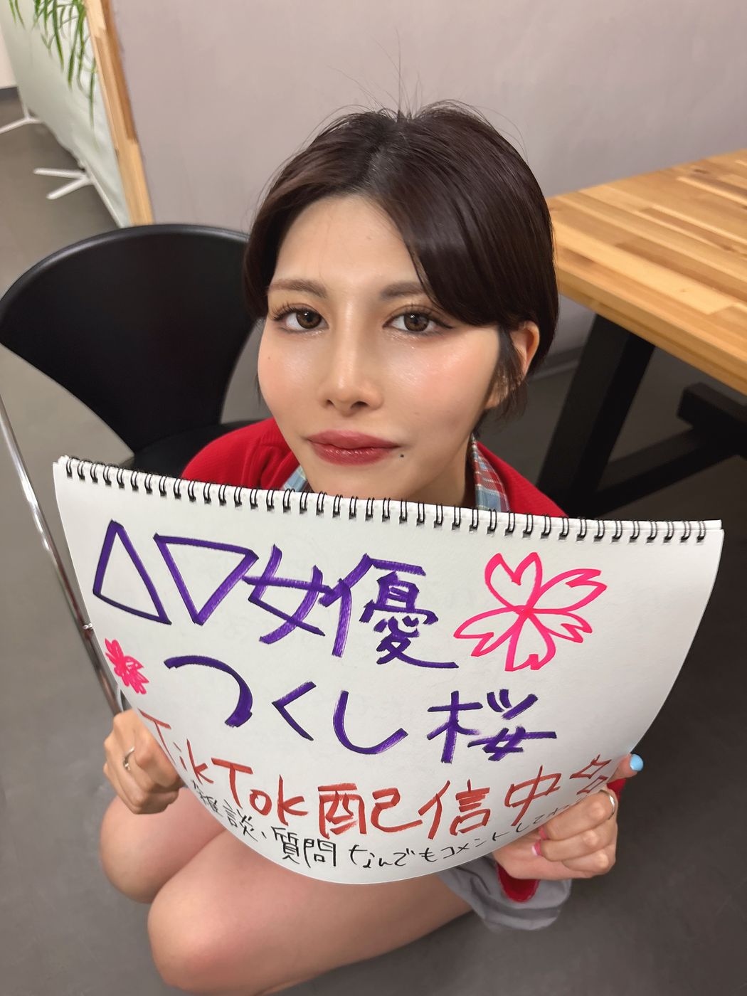 TikTok配信中と書いたスケッチブックを持つタレント
